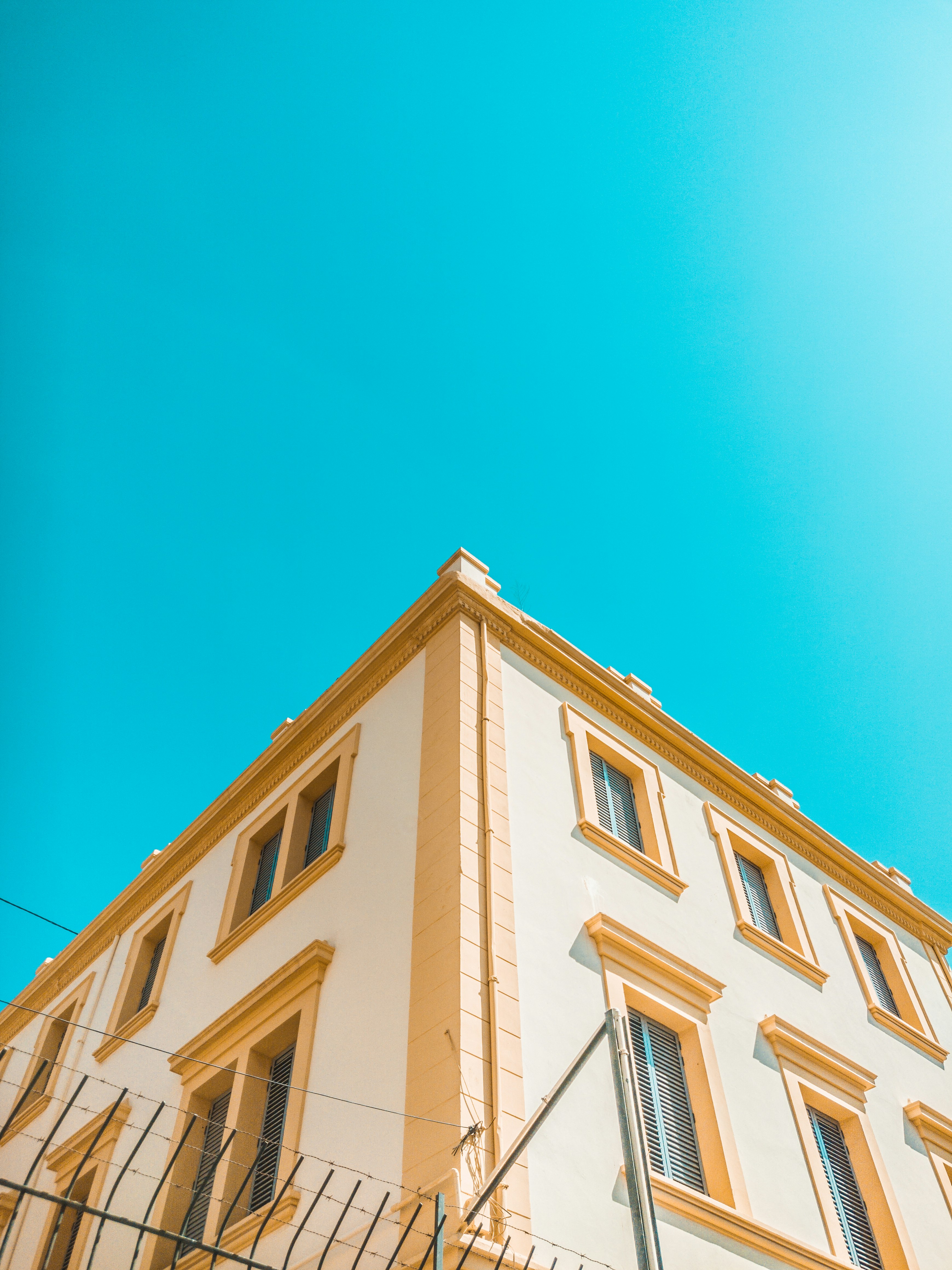 worm's-eye view photography of yellow and brown concrete house under clear sky